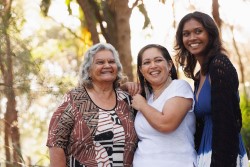 Three smiling women standing together in a group